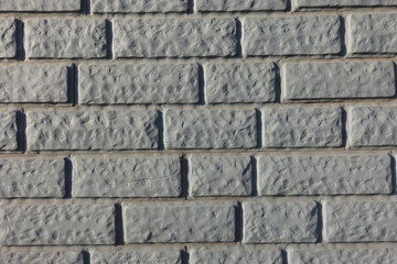 Close view of Light grey painted brick veneer wall