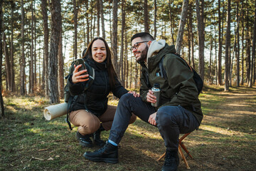 Fototapeta premium Young caucasian couple boyfriend and girlfriend hike or trek through the forest 