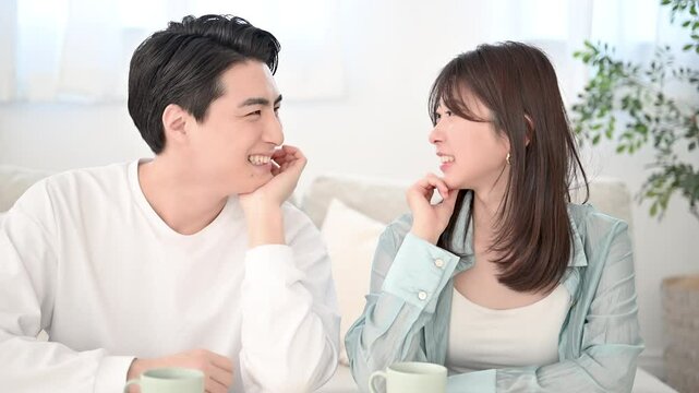 リビングでくつろぐ見つめ合う若いカップルの動画