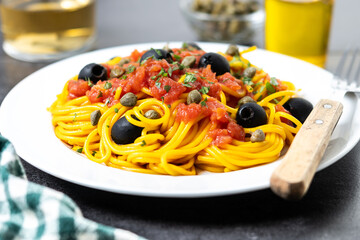 Italian Pasta puttanesca with tomato sauce, capers, and black olives
