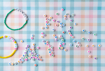 Handmade bracelet with letter beads. Flat lay, top view.