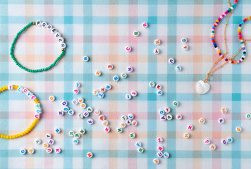 Different beaded jewelry with letter beads. Flat lay, top view.