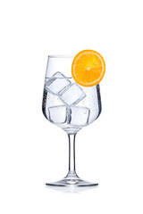 Sparkling water with ice cubes in a wine glass isolated on white