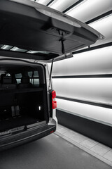 White van with opened trunk hatch. Seat backs of passenger interior in the background. 