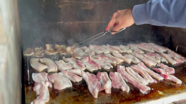 Barbeque with raw pancetta. Smoking outdoor grill. Copy space.