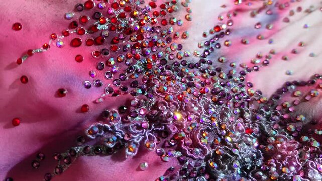 Rhinestones on the pink fabric, background. Sew clothes.