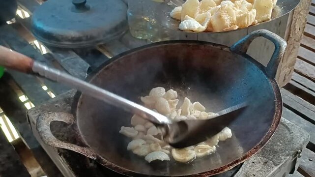 Crackers fried in a frying pan with hot oil. Fried Crackers, typical Indonesian crackers