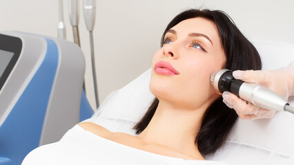 Close-up of a young girl undergoing fractional radiofrequency facelift at a medical center, skin...