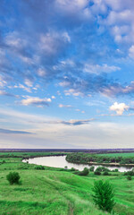 Obraz premium Beautiful landscape with a river and a green field