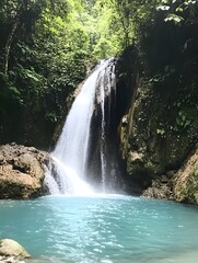 Obraz premium a hidden waterfall cascading into a turquoise pool, surrounded by lush greenery.