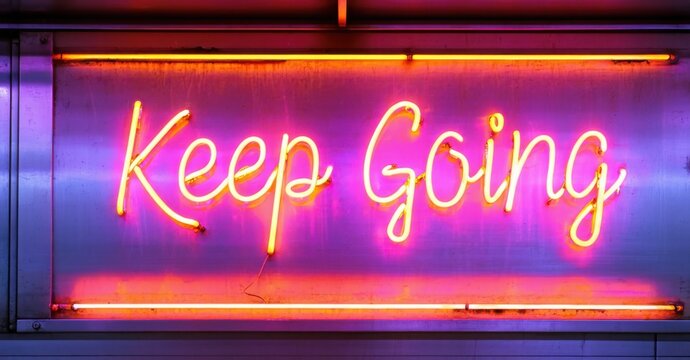 Naklejki Neon sign keep going vibrant violet orange glowing inside city subway station casting reflections metallic train doors