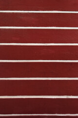 Fototapeta premium Deep red wall with white horizontal stripes