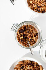Glass Storage Jar with Freshly Baked Granola on White Table. Breakfast Preparing.