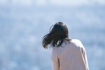 体を傾けて髪をなびかせる女性, 後ろ姿