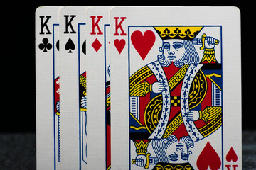 Set of four Kings from a deck of playing cards, arranged in a row. A powerful hand symbolizing strength, strategy, and high-stakes gambling.
