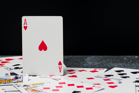 Ace of Hearts stands upright on top of a scattered pile of playing cards. The scene evokes anticipation and excitement, with the Ace symbolizing the highest card in a deck.