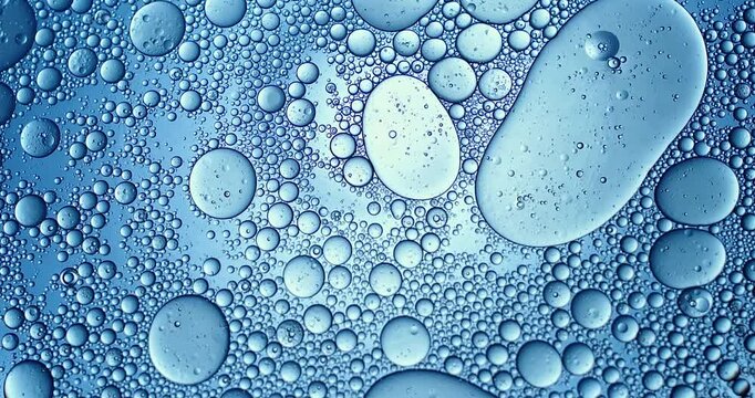 Slow motion macro of floating micro particles molecules in liquid are analyzed with microscope by chemist during innovative new medical research and analysis in scientific pharmaceutical laboratory.