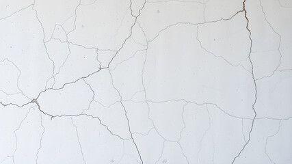 Fototapeta premium A weathered gray wall with cracked paint and rough, aged grunge texture