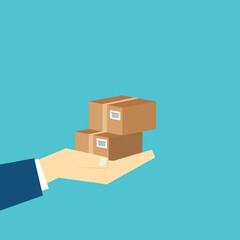 Delivery person hand holding two cardboard boxes, showcasing typical package delivery scenario.
