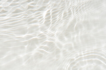 White water with ripples on the surface. Defocus blurred transparent white colored clear calm water surface texture with splashes and bubbles. Water waves with shining pattern texture background.