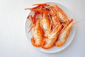 Boiled prawn in white ceramic plate on white background , top view food table with free copy space