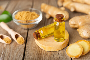 Ginger essential oil on texture background. Fresh ginger slices. Essence, serum, oil. Alternative...