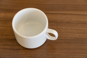 Empty white coffee cup on a wooden table