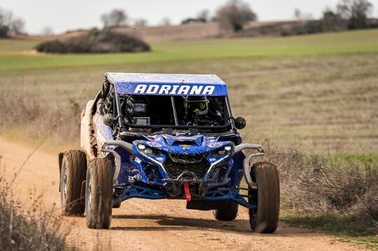 Madrid, Spain; 02-15-2025: Can-Am Maverick X3 buggy speeds on a dirt track, its agile maneuvering and dust trail highlighting the adventurous spirit of off-road racing