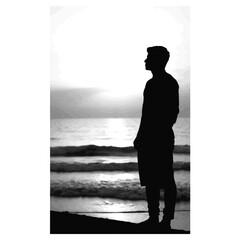 Silhouette of individual observing tranquil sunset at beach, reflection