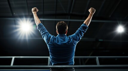 A man celebrating with raised arms in bright indoor setting, expressing joy and triumph. atmosphere is energetic and uplifting