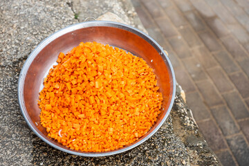 Pilaf preparation in a pot on an open fire. Cubed carrots frying in oil.