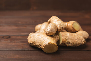 Fresh ginger on wooden background. Dry ginger. Sliced ​​ginger with honey and lemon. Ginger root. Traditional alternative medicine, healing tea for immunity. Seasoning and spices concept. Copy space.