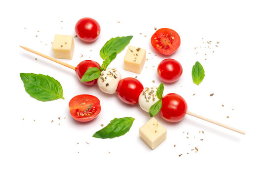 Caprese skewer with cherry tomatoes and basil leaves on a white background