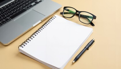 Fototapeta premium Laptop and notebook on a desk with yellow paper, pen, and plain background, writing in journal, office flatlay, high resolution.