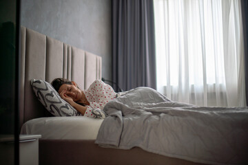 Woman Bedroom Sleep Insomnia: Woman suffering insomnia sleeps in bed, daytime, feeling unwell.