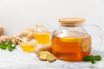 Cup of hot ginger tea with slices of ginger root on wooden background. Warming drink. Alternative medicine. Tea with honey, lemon, ginger and mint. Space for text. Copy space
