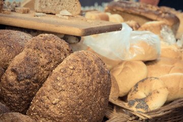 Fresh traditional loaves of wheat or rye bread with grains on stall or in bakery