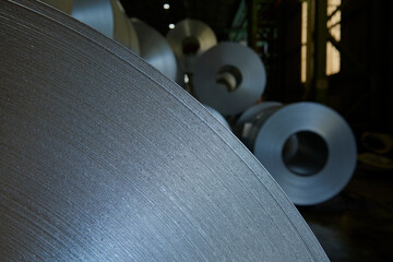 Galvanized steel coil detail and factory background.