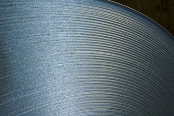 Galvanized steel coil detail and factory background.