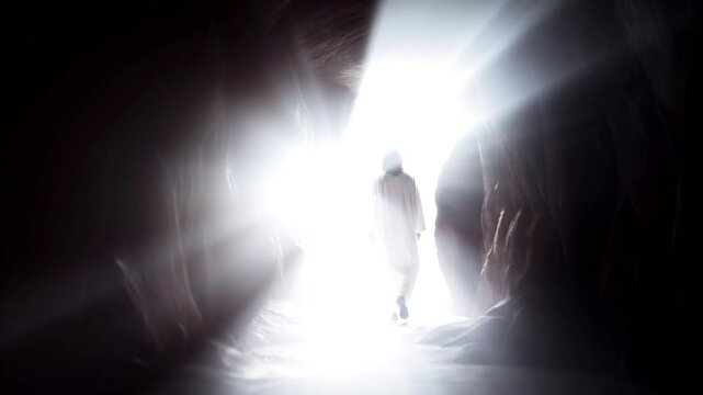 Jesus Christ risen from the dead, silhouette of Jesus walking out of a stone tomb toward bright light

