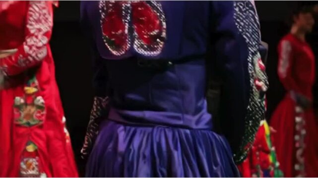 Showcase traditional Mexican clothing like charro suits and colorful dresses in a fashion show. Use close-ups to highlight the intricate details and patterns.