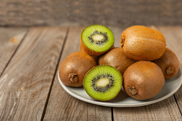 Kiwi on wooden background. Whole fruit and slices pieces of green kiwi on table. fresh ripe juicy...