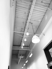 plafond blanc avec lampes dans un bâtiment moderne, photo en noir et blanc
