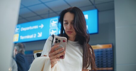 Airport Terminal: Adult Woman Scanning Plane Ticket Using Smartphone to Check Flight Information....