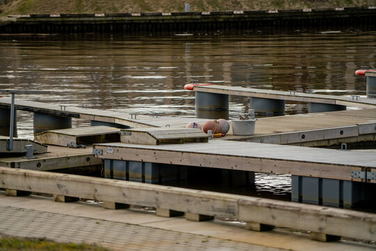 Small empty water docks for small private harbor and yachts placement in river at small tourist Latvian city of Pavilosta