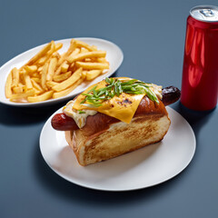 Cheese Hot Dog with French Fries and a Soda Can on a Blue Background