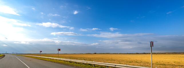 Road with a few signs and a few cars on it