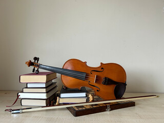 a composition of a vintage book, orange violin, chess board on the table, white background,  © KarinaSyrotiuk