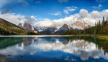 majestic mountain range reflecting in a serene blue lake under a cloudy sky