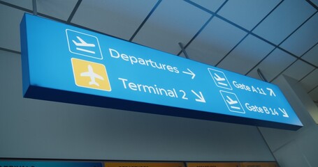 Blue Navigation Sign Directing Passengers to Departures, Terminals And Gates for Boarding Airplane...